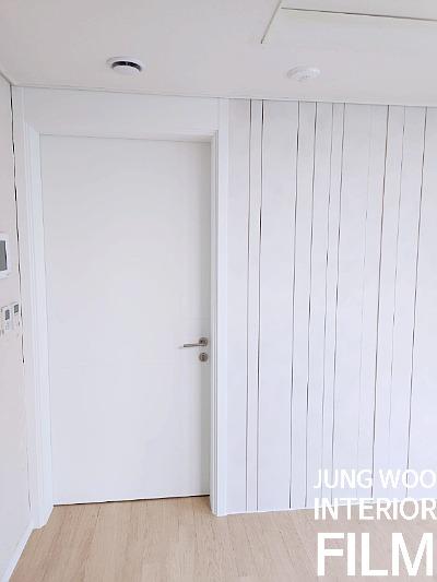 세로 패턴 벽면과 화이트 도어의 조화로운 현관