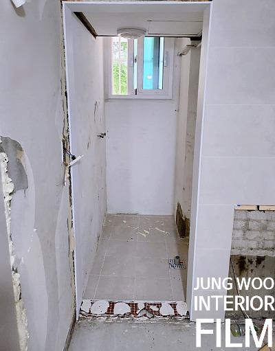배수구가 있는 타일 바닥과 창문 쪽 복도