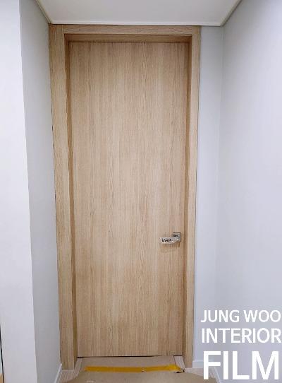베이지 빛 목재 패턴이 돋보이는 도어 근접샷