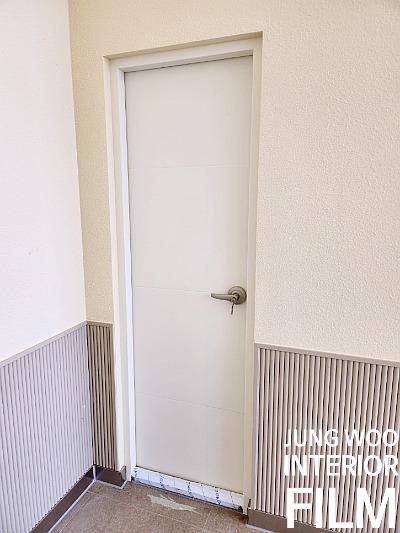 베이지색 문과 금색 손잡이가 있는 현관 공간