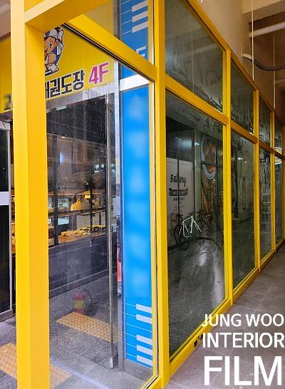 4F 표시가 보이는 노란색 프레임의 건물 입구