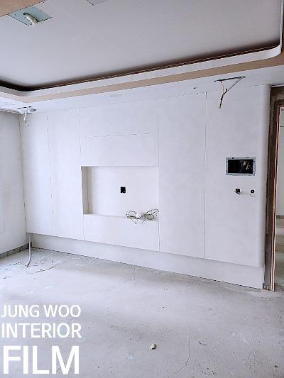조명 설치 중인 흰색 벽면과 바닥의 실내 공간