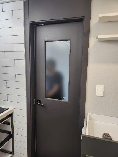 여닫이 도어의 힌지와 유리 패널 근접 모습