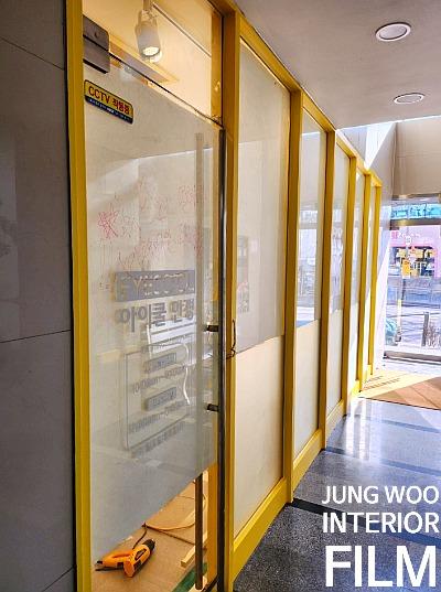 CCTV 표시와 문구가 적힌 노란 프레임 유리문들