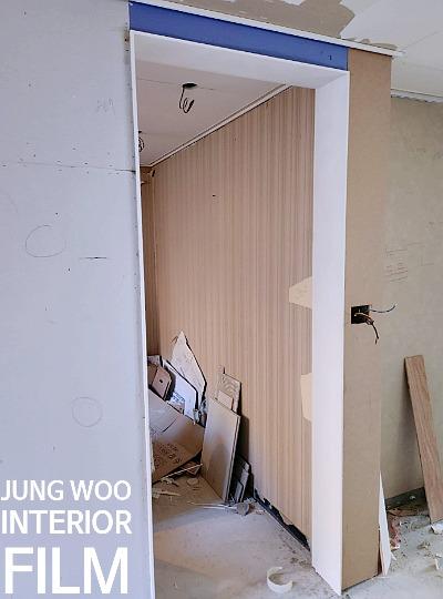 베이지색 패널과 흰색 보드가 설치 중인 벽면