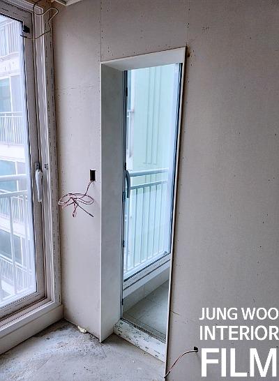 유리문과 노출 전선이 보이는 흰색 벽면 공간