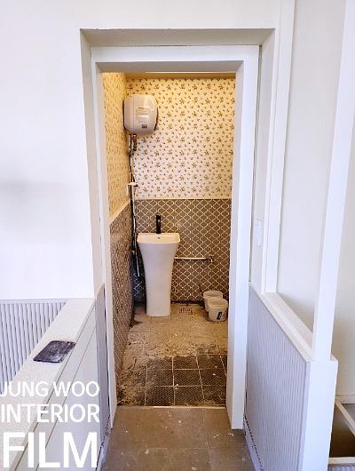 샤워 설비와 벽 타일 줄눈이 보이는 욕실