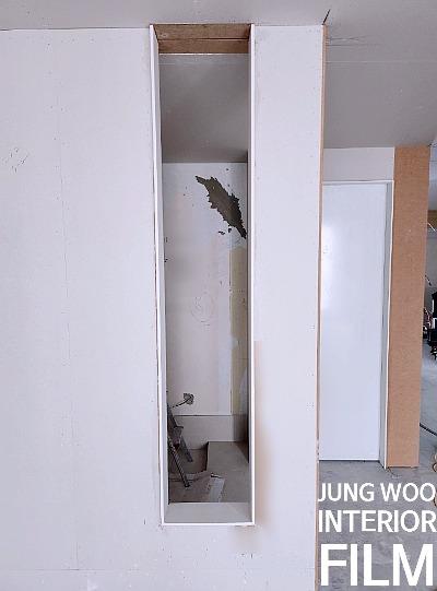 흰 벽면에 상판이 설치된 공사 중인 공간
