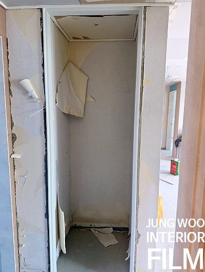 흰색 보드가 붙어 있는 복도 벽면과 콘크리트 바닥