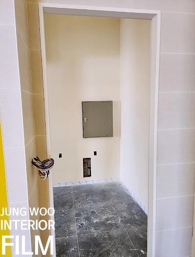 베이지색 마감 벽면과 전선이 노출된 공사 현장