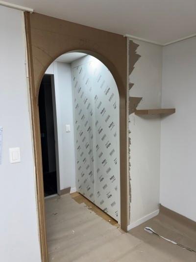 흰색 도배지와 보조재가 설치된 복도 벽면