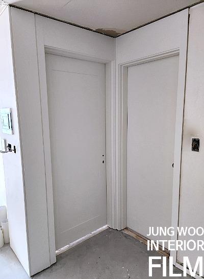 흰색 문과 문틀이 적용된 복도 전경