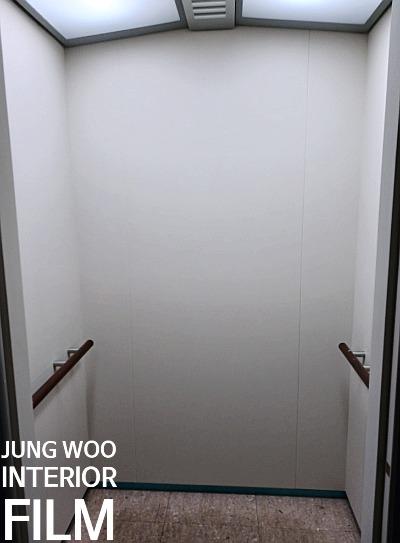 나무 손잡이가 설치된 타일 바닥의 복도