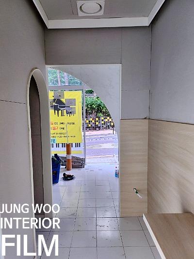 회색 벽지와 베이지색 수납장이 배치된 복도