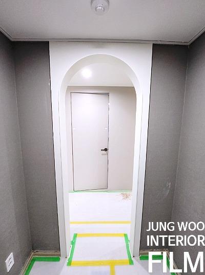 흰색과 회색 벽면이 교차하는 복도 구간의 마감 전 모습