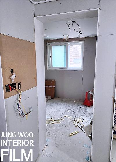 자재 조각이 흩어진 방의 창문과 벽면 전선