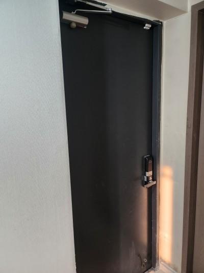 검은색 도어와 금속 핸들이 보이는 시공 전 현관