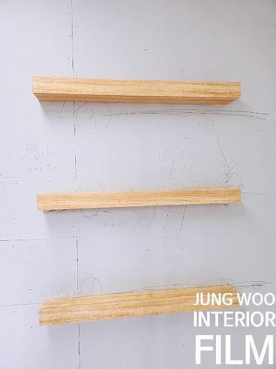 설계도면 위에 놓인 나무 재질의 샘플 블록