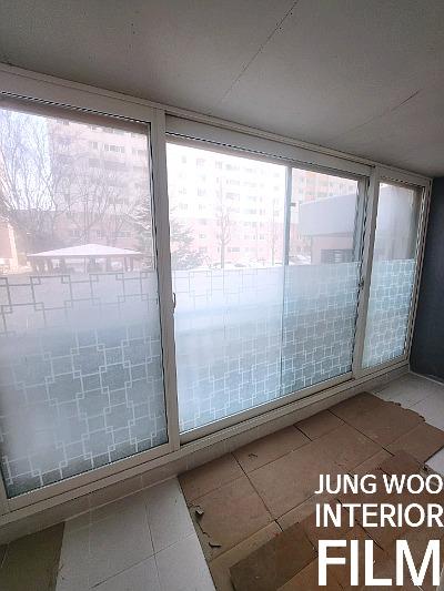 격자 무늬 투명 필름이 부착된 창호 시공 중인 모습