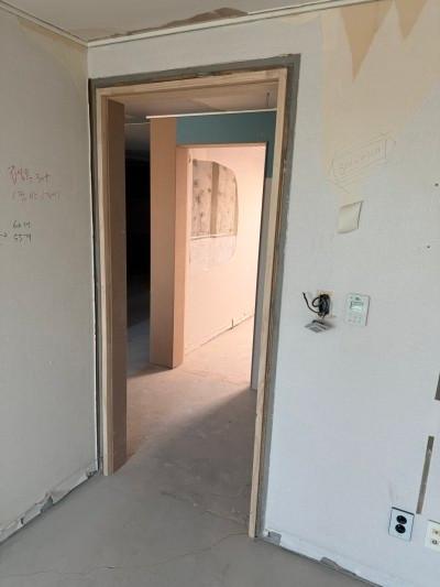부분 도배된 흰 벽면과 설치된 문틀