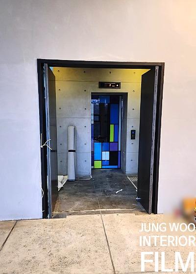 다채로운 유리 패널의 엘리베이터 입구와 흰색 벽면