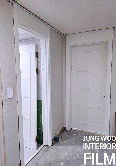 흰색 도어와 문틀이 배치된 복도