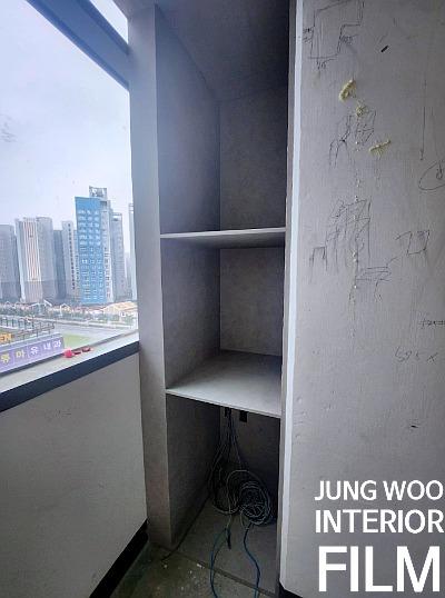 창가 벽면에 배치된 빈 수납장과 외부 풍경