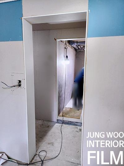 전등이 매달려 있고 전선이 노출된 공사 중인 복도