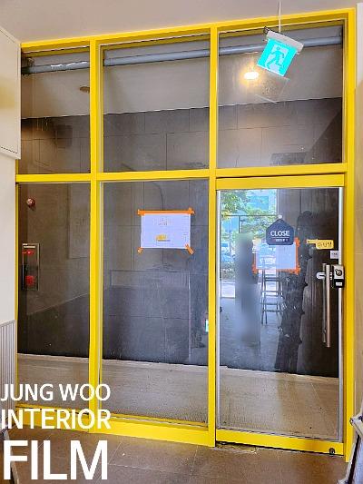 노란 프레임의 유리문과 'CLOSE' 표시가 보이는 공간
