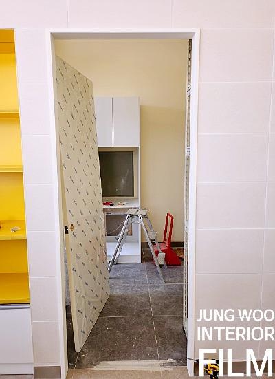 흰 벽돌 타일과 노란색 선반이 배치된 실내 전경