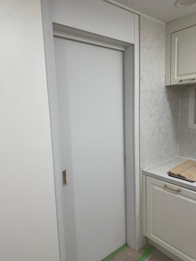 마블 패턴 벽지와 화이트 수납장이 있는 주방