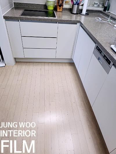 흰색 수납장과 그레이 상판으로 마감된 시공 후 주방