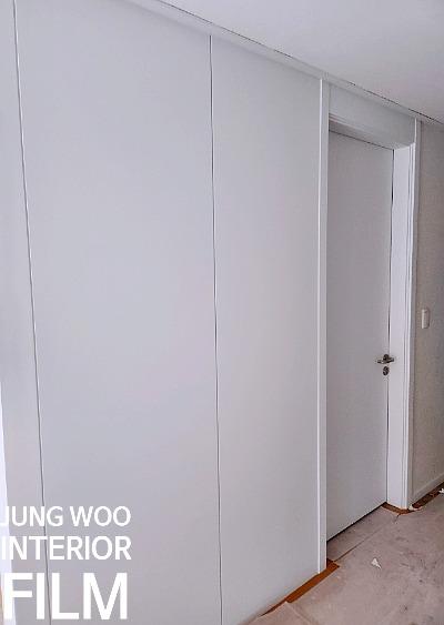 화이트 슬라이딩 도어 작업이 진행 중인 복도
