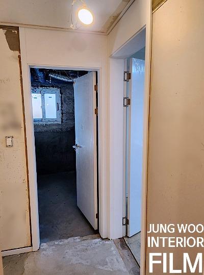 벽면 흠집이 보이는 복도와 열린 문틈