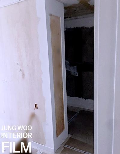 벽면 보드가 노출된 공사 중인 복도