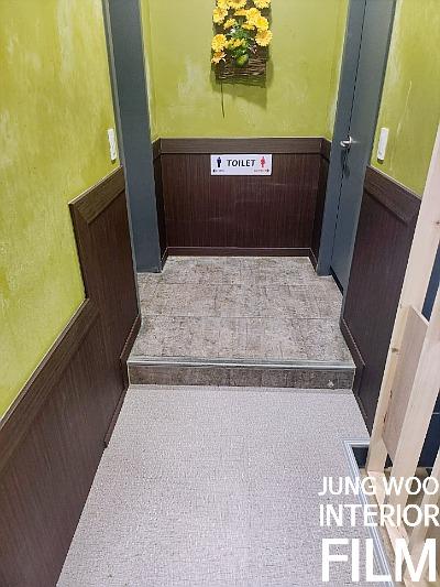 녹색 벽면과 갈색 패널이 대비되는 복도 전경
