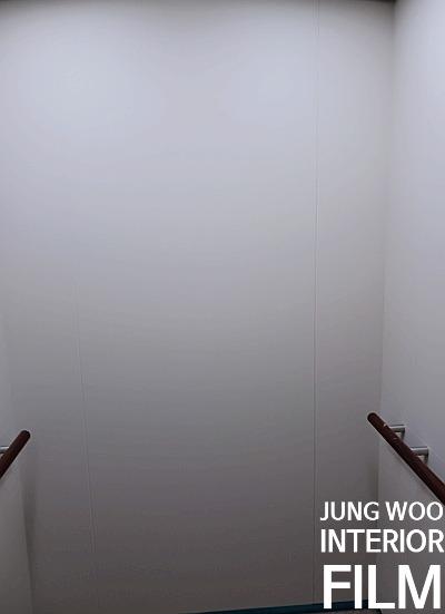계단 옆 복도 벽면과 나무 손잡이