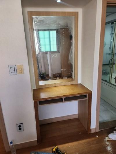 목재 데스크와 거울이 어우러진 파우더룸의 디테일