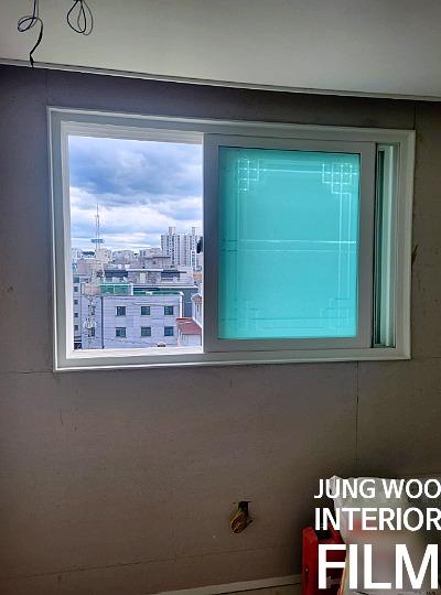 푸른색 보호 필름이 덮인 흰색 창호 프레임