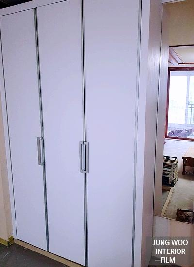 화이트 톤의 수납장과 금속 손잡이가 조화를 이루는 드레스룸