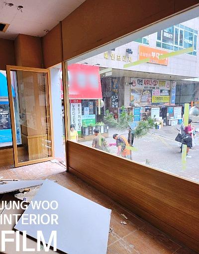 열린 유리문과 바닥의 흰색 보드가 보이는 실내