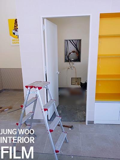 노란 선반과 사다리가 놓인 빈 공간의 모습