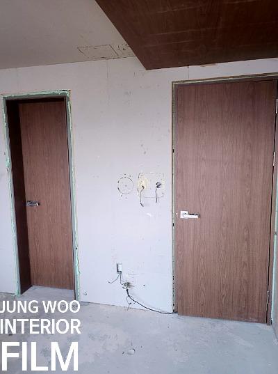 전선이 노출된 벽면과 우드톤 도어 두 개