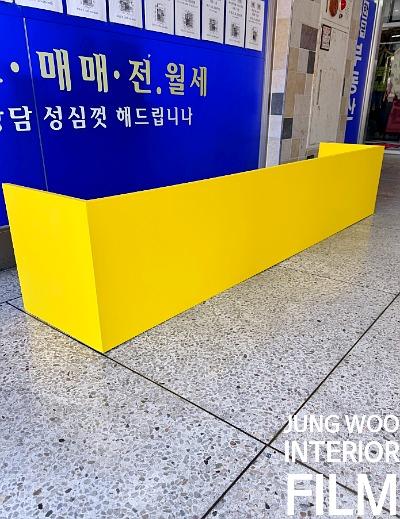 노란색 구조물과 파란색 배경의 문구가 보이는 실내