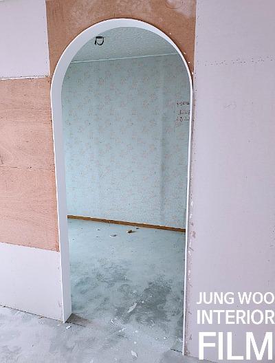 벽지에 흰색 글씨가 표기된 아치형 문 내부