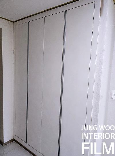 흰색 슬라이딩 문과 금색 테두리가 보이는 공간