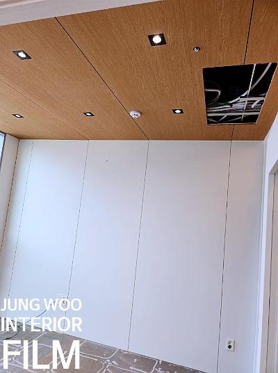 나무 패턴 천장과 밝은색 평면 패널 벽면