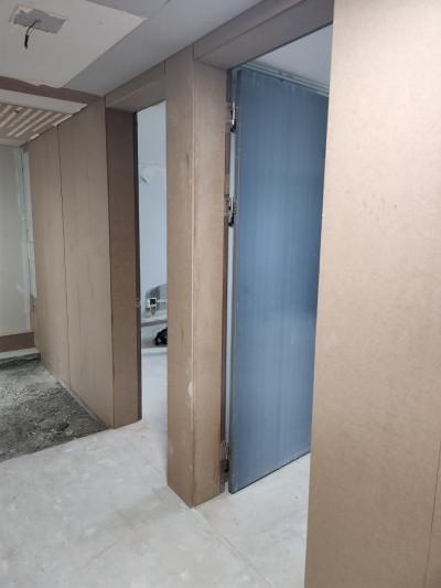 베이지색 마감과 파란색 도어가 보이는 복도
