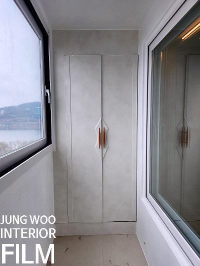 회색 벽면과 흰색 도어가 배치된 발코니 공간