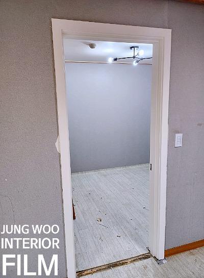 흰색 타일 바닥과 문틀이 맞닿은 내부 공간